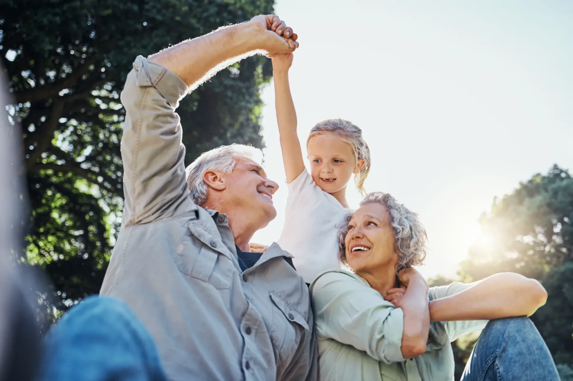 Grandparents and their granddaughter playing together in a park