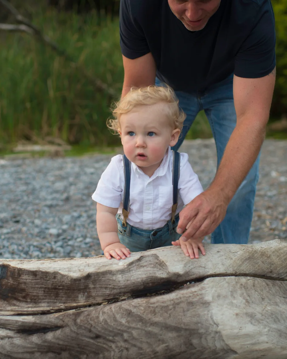A father walking with his toddler on the beach
