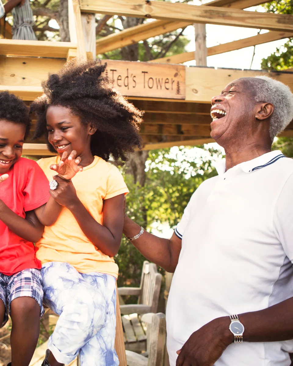 A grandfather laughing with his grandchildren